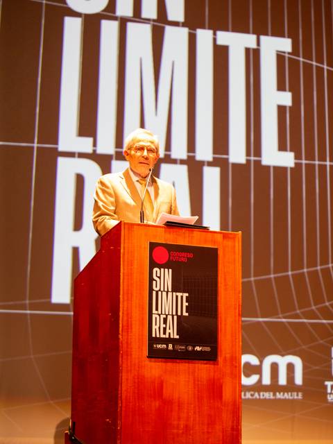 Un orador en un escenario frente a un fondo con el texto 'SIN LIMITE REAL'.