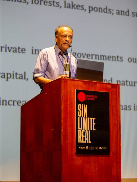 Un hombre de pie detrás de un podio habla durante una conferencia.