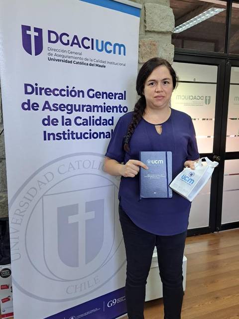 Una persona sostiene dos documentos frente a un cartel de la Dirección General de Aseguramiento de la Calidad Institucional.