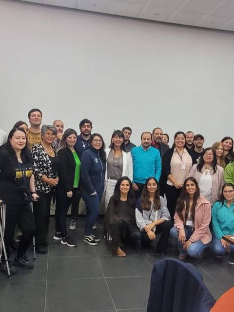 Un grupo numeroso de personas posando juntas en un salón de eventos.