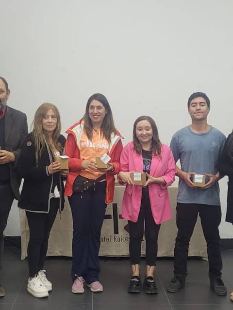 Grupo de personas posando con objetos en un evento en la Universidad de Concepción del Maule.