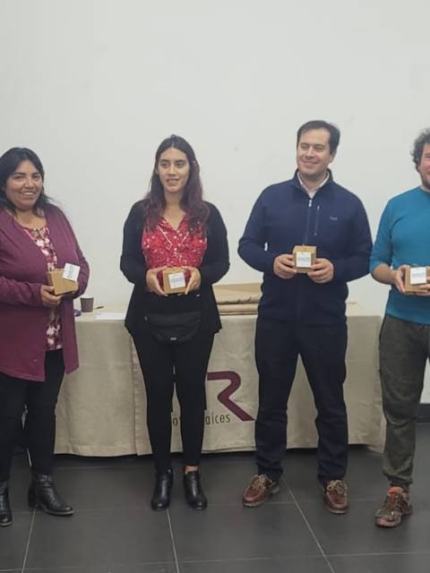 Un grupo de personas se encuentran en un evento, sosteniendo trofeos o reconocimientos en un salón que promueve la sostenibilidad.