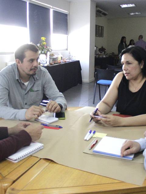 Un grupo de cuatro personas discutiendo en una reunión en una oficina.