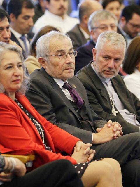 Un grupo de personas sentadas en un auditorio durante un evento formal.