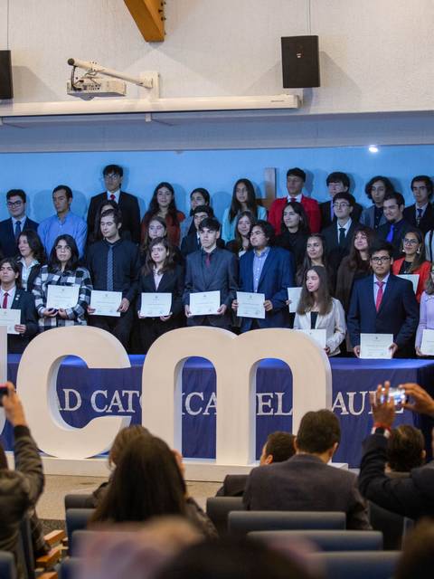 Un grupo de estudiantes de la Universidad Católica del Maule posando con sus certificados durante una ceremonia.