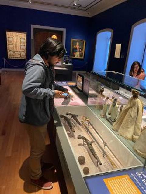 Una persona observa objetos antiguos en un museo.