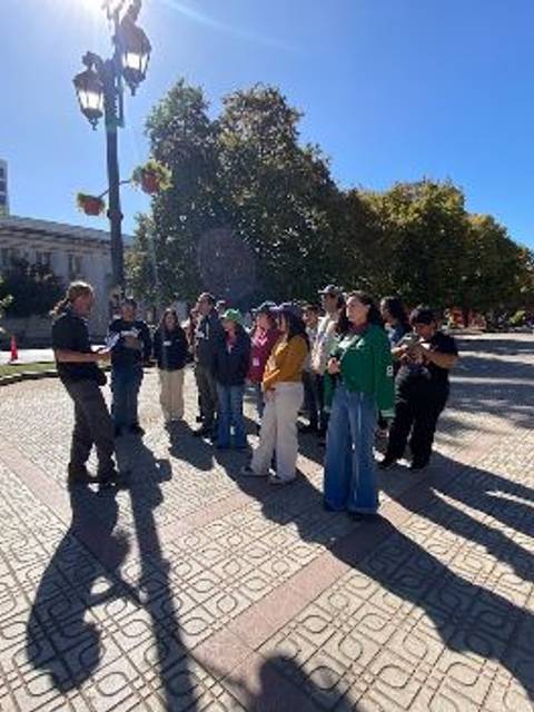 Un grupo de personas se reúne en una plaza al aire libre, disfrutando de un día soleado.