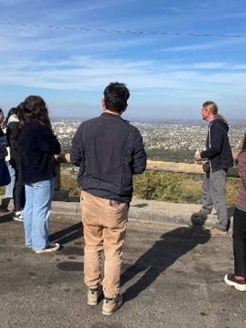 Un grupo de personas observa un paisaje desde un mirador.