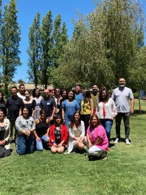 Grupo de personas posando en un parque durante un día soleado.