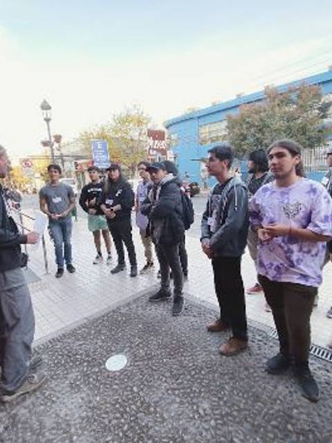 Un grupo de personas escucha atentamente a un guía en una calle de la ciudad.