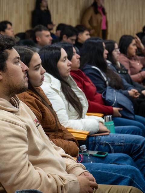 Un grupo de personas escucha atentamente en un evento o conferencia.