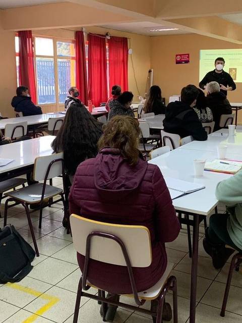 Un grupo de personas participa en una capacitación en un salón amplio.