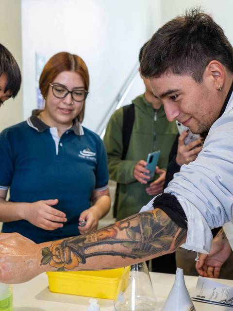 Un grupo de estudiantes realiza una actividad práctica en un laboratorio, observando los resultados de un experimento.