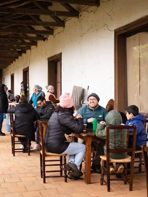 Un grupo de personas se reúne en un patio, disfrutando de un día lluvioso.