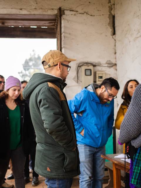 Un grupo de personas está siendo recibido en un lugar con un cartel que dice 'Bienvenido a Huilquilemu'.