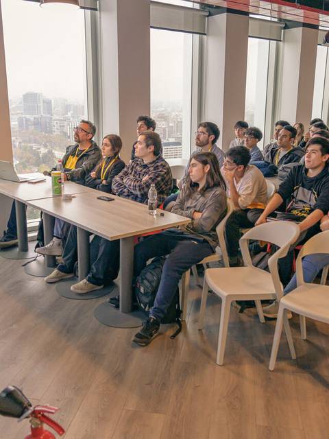 Una presentación frente a un público atento en un ambiente moderno y luminoso.
