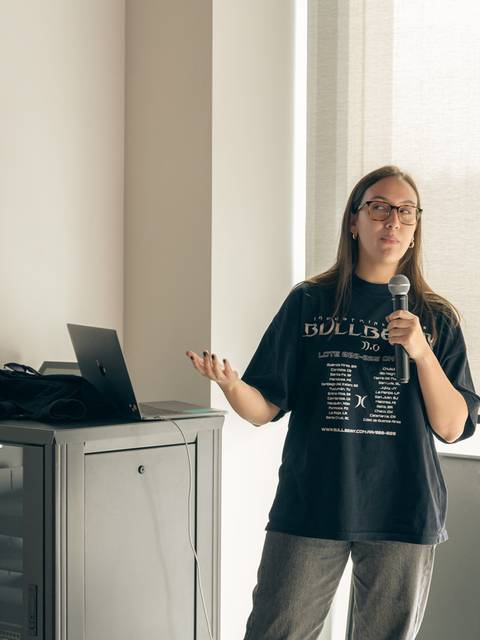 Una persona está presentando en un evento mientras sostiene un micrófono.