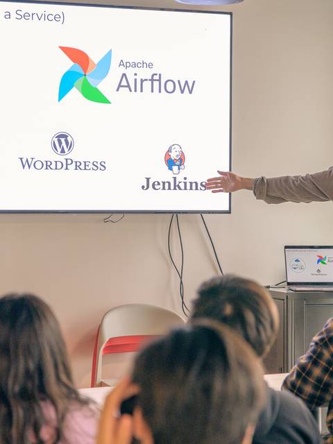 Una persona presenta conceptos de SaaS mientras muestra logos de distintas herramientas en una pantalla.