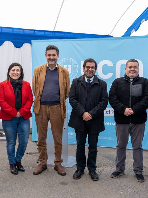 Un grupo de seis personas posando frente a un fondo con el logotipo de la universidad.