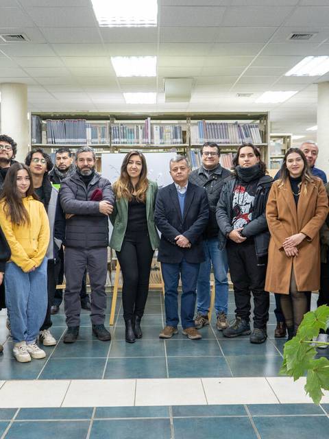 Un grupo de personas posando en una biblioteca.
