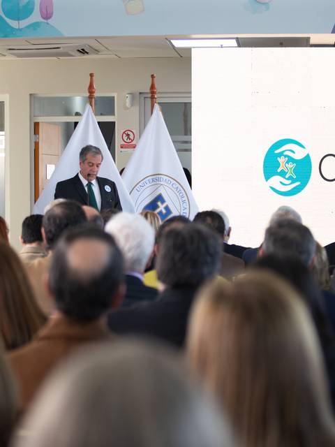 Un evento formal en el que un ponente se dirige a un grupo de personas sentadas en un auditorio.