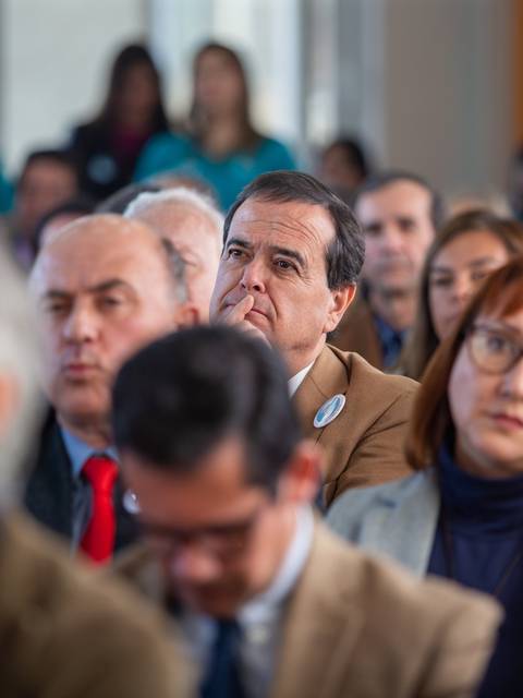 Una multitud de personas atenta a un evento en un salón.
