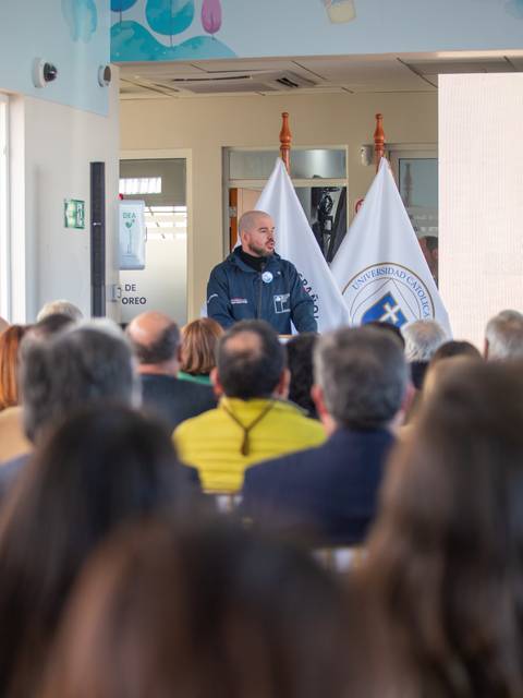 Un hombre habla frente a un público en un evento en la universidad.