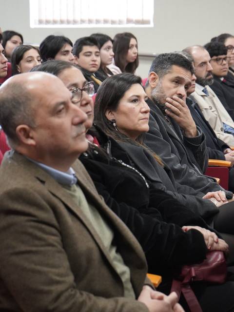 Un grupo de personas sentadas en un auditorio durante un evento.