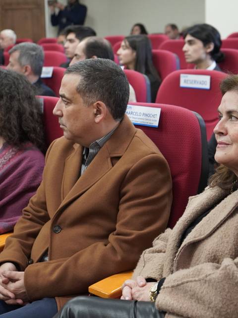 Un grupo de personas sentadas en un auditorio durante un evento.