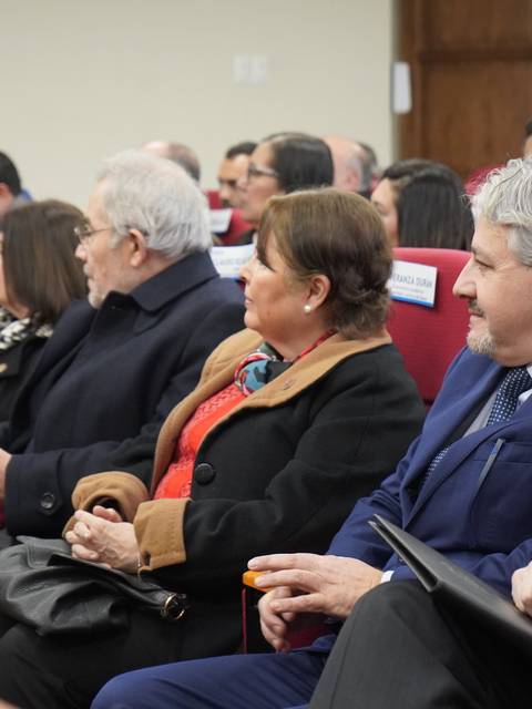 Un grupo de personas sentadas en un auditorio durante un evento formal.