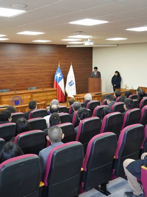 Una sala de conferencias con una audiencia sentada y un escenario al frente.