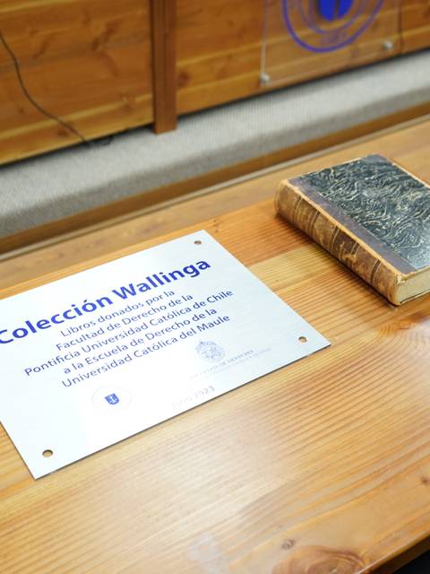 Imagen de una placa sobre una mesa que describe la Colección Wallinga y un libro antiguo colocado al lado.