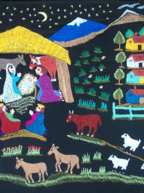 La imagen muestra una escena de un nacimiento con figuras que representan a la Virgen María, San José, los Reyes Magos y animales, todo en un entorno rural decorado con montañas y casas.