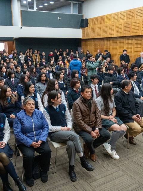 Una multitud de personas sentadas en un auditorio durante un evento.