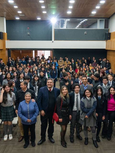 Un gran grupo de personas posando para una fotografía en un auditorio.