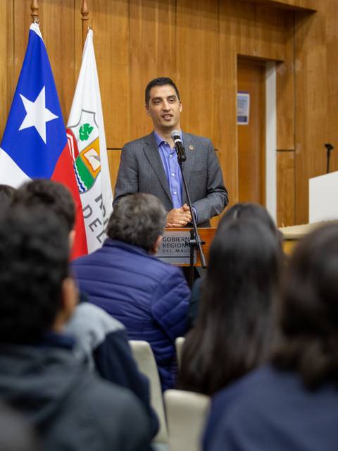 Un hombre está hablando frente a un público en un evento oficial en Chile.