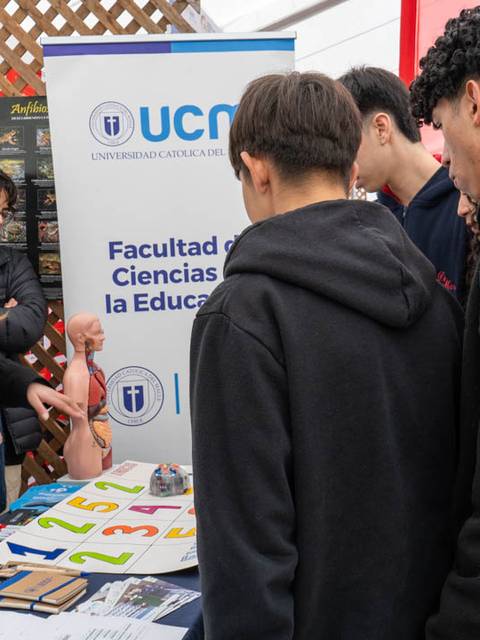 Un grupo de estudiantes observa una exhibición educativa organizada por la Universidad de Ciencias de la Educación.