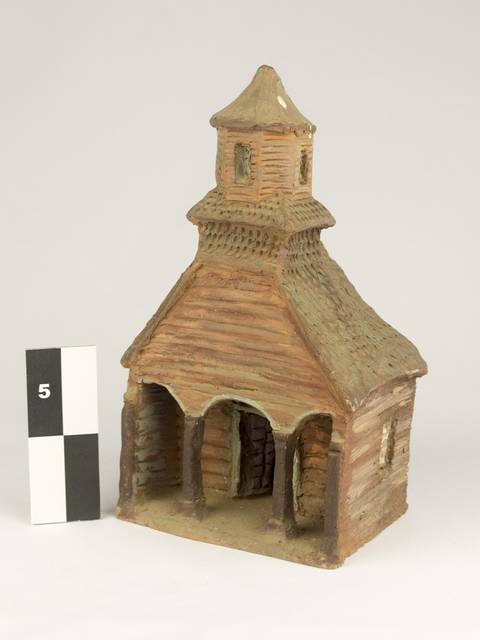 Se observa una construcción en miniatura que simula una iglesia de estilo rústico.