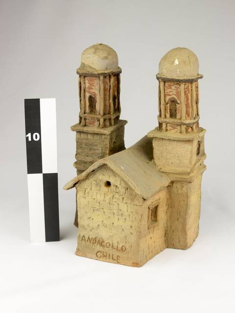 Una escultura de una construcción con dos torres, representando un edificio tradicional de Chile.