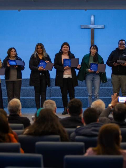 Un grupo de personas recibe premios en un evento en una iglesia.