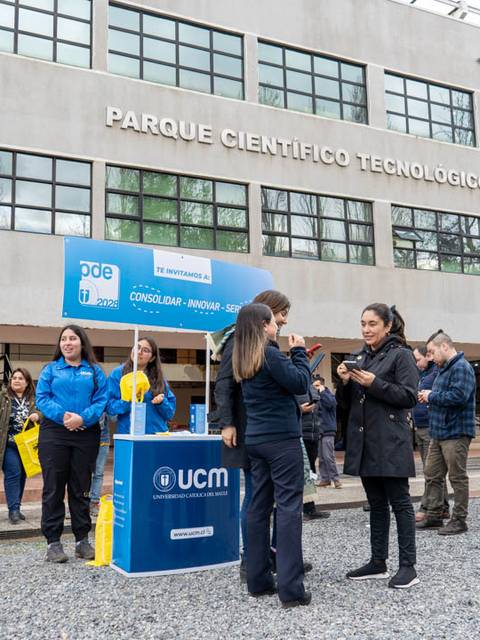 Imagen de un evento en el Parque Científico Tecnológico con diversas personas interactuando y stands informativos.