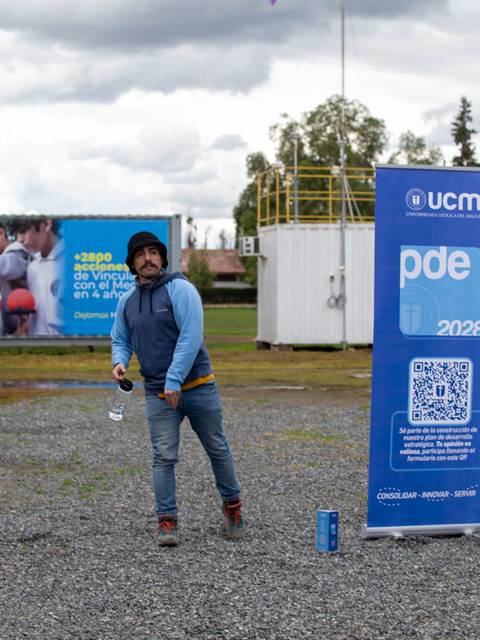 Un hombre lanza un objeto mientras una cometa vuela en el cielo.