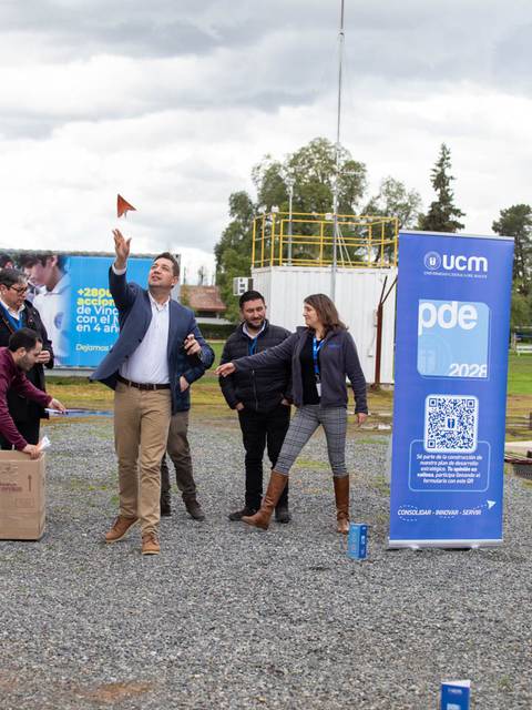 Un grupo de personas participa en una actividad al aire libre, mientras una persona lanza un objeto con entusiasmo.