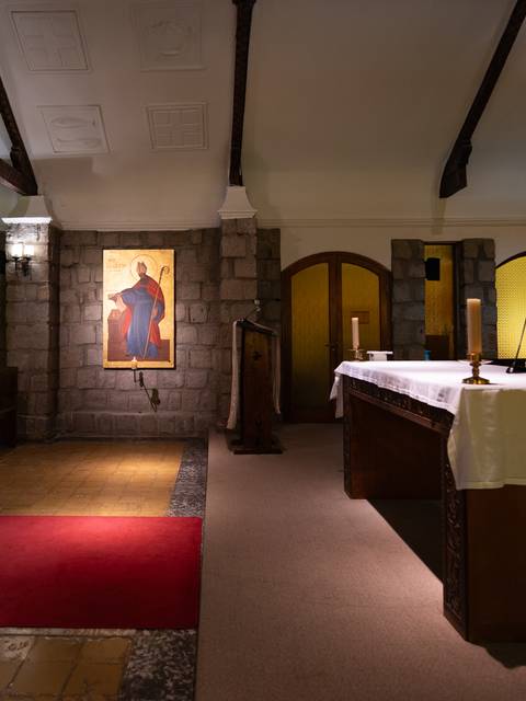 Una vista interior de una iglesia con un altar y una imagen religiosa en la pared.