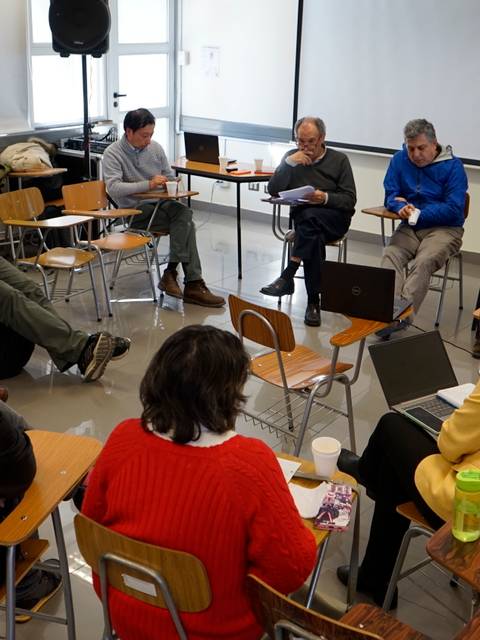 Un grupo de personas sentadas en un aula participando en una discusión.