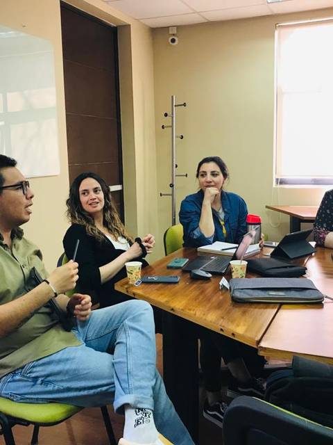 Un grupo de cuatro personas conversando en una sala de reuniones.