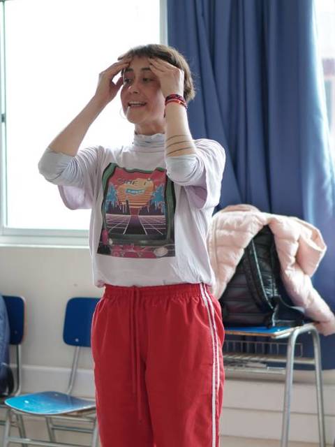 Un grupo de personas practica una actividad en un salón con luz natural.