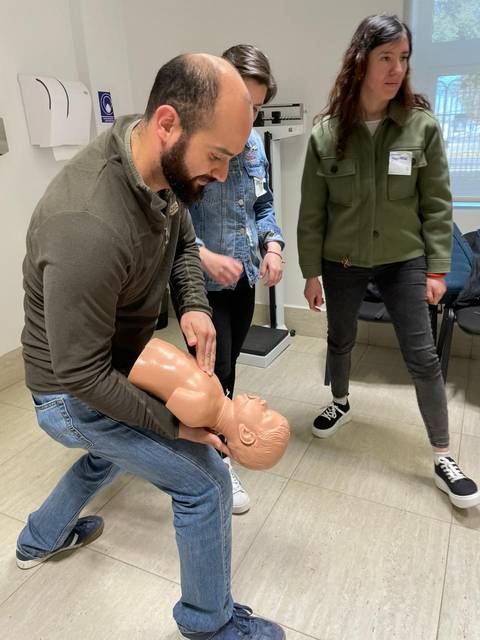Un grupo de personas realiza una práctica de primeros auxilios con un maniquí.