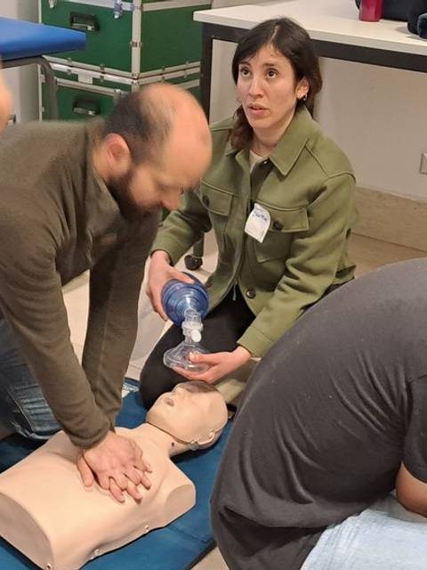 Un grupo de personas realiza un entrenamiento en reanimación cardiopulmonar utilizando un maniquí.