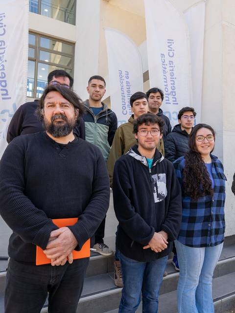Grupo de personas posando en las escaleras de un edificio moderno.